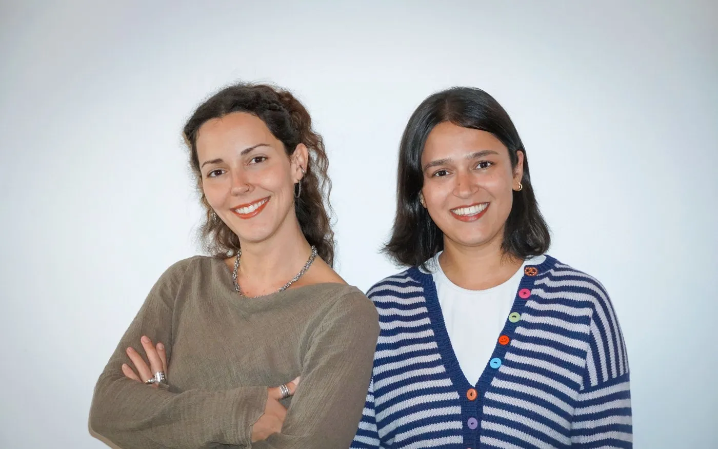 Two women standing side by side, smiling